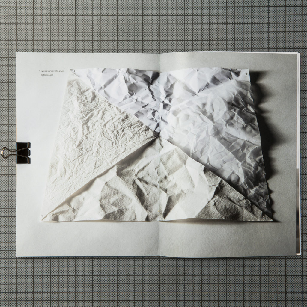 the interior page shows a photograph of four different triangular crumpled papers which are combined to a square