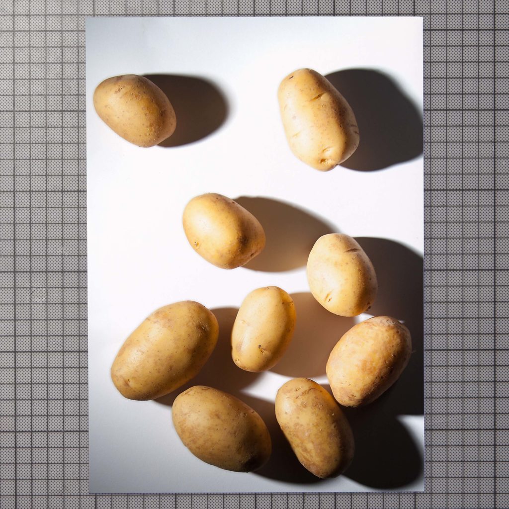 auf der fotografie sind kartoffeln in dramatischem licht abgebildet.